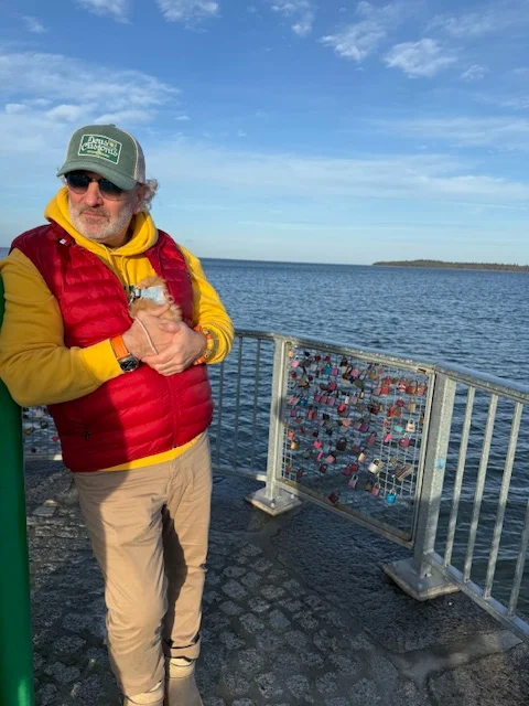 Der Makler mit seiner Huendin, angelehnt mit Blick aufs Meer bei bestem Wetter
